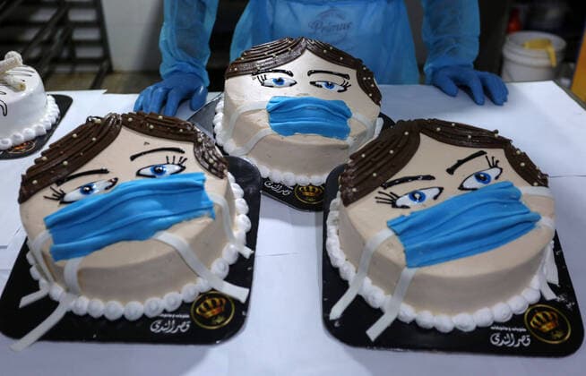 March 30, 2020, Khan Yunis, Gaza Strip, Palestinian Territory: Palestinians put final touches on cakes that portrays a woman wearing a facemask, at their shop in Khan Yunis in the southern Gaza Strip on March 30, 2020. The United Nations has warned that a COVID-19 outbreak in Gaza could be disastrous, given the high poverty rates and weak health system in the coastal strip under Israeli blockade since 2007. Authorities in Gaza have said that more than 2,700 Palestinians are in home-isolation, mostly people who had returned from Egypt Khan Yunis Palestinian Territory - ZUMAap3_ 20200330_zaf_ap3_146 Copyright: xAshrafxAmrax