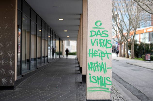 Unknown persons smear a wall of a C and A shop in the city center of Jena with a virus called capitalism downtown Jena