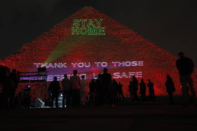 (200331) -- GIZA, March 31, 2020 (Xinhua) -- People gather near the Pyramid of Khufu illuminated with text Stay home, thank you to those keeping us safe in Giza, Egypt, March 30, 2020. Egypt said on Monday it has recorded 47 new COVID-19 positive cases and one more death, raising the number of confirmed cases to 656 and the death toll to 41. (Str Xinhua) EGYPT-GIZA-COVID-19-PYRAMIDS-ILLUMINATION 