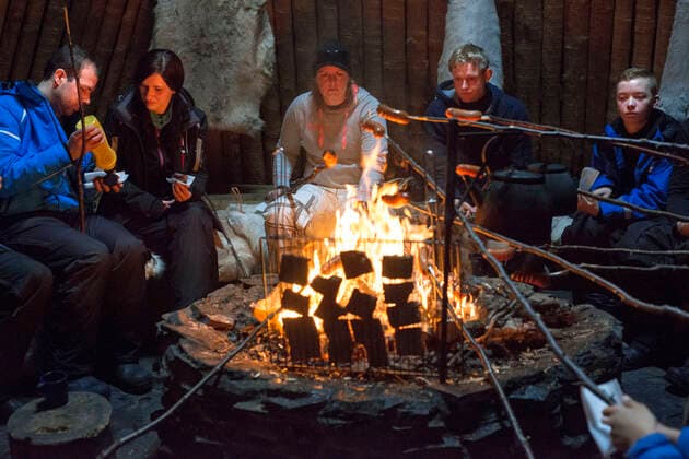 Salla, Lapland, Finland. People cooking reindeer meet burgers inside in a typical huts. Turf huts have very basic facilities and there is typically a stove or fireplace, and a dry toilet for use. Some have bunks while others only offer the ground to sleep. One of the best things about traveling and hiking in the far north is the extensive network of open wilderness huts in Lapland which are free and open for everyone to use, local and foreigners, Salla Lapland Finland Copyright: xSergixReboredox REB-075-DI2923