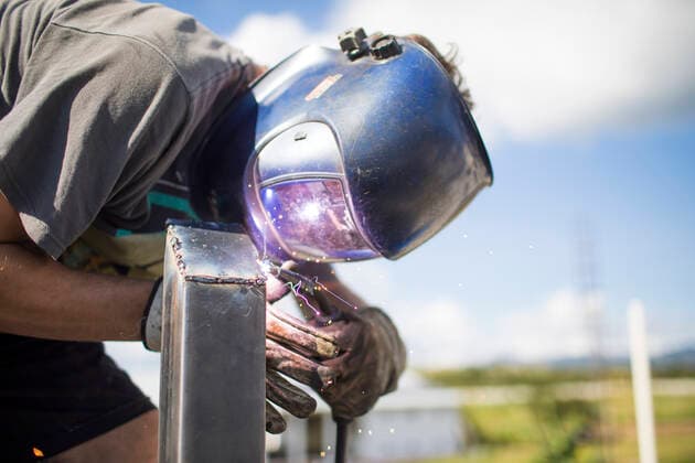 close up view of man welding outdoors on rooftop. Monjas, Jalapa Department, Guatemala ,model released, Symbolfoto ,property released CR_JDIP200326A-316138-01