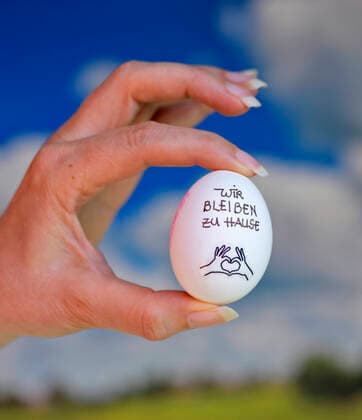 31 03 2020, symbolic picture Slogan We stay at home on a hens egg A slogan because of the corona crises Output restriction in Germany 31 03 2020, egg with corona Slogan 31 03 2020, egg with corona Slogan