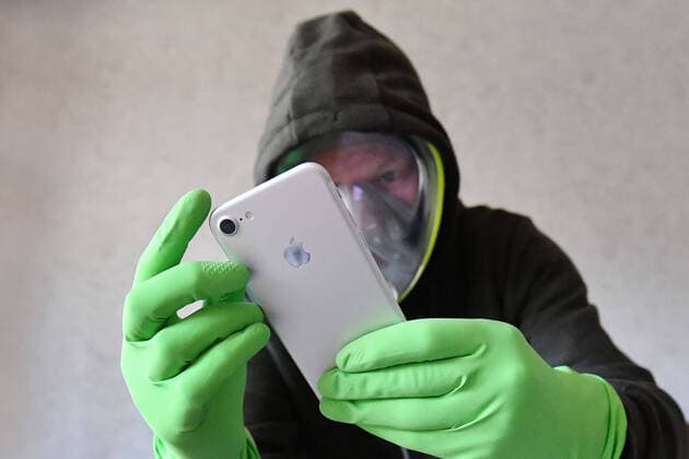 Topic picture Corona App Fight against the pandemic The Corona App must come as quickly as possible In the fight against Corona, the area-wide evaluation of mobile phone data was brought into play to identify chains of infection Person holds his smartphone with protective gloves and wears a full face mask, mask,face mask,mouthguard