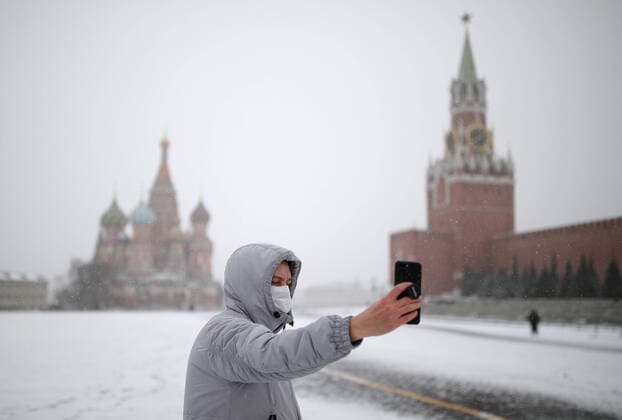 MOSCOW, RUSSIA - MARCH 31, 2020: A man wearing a protective face mask takes a selfie in Red Square. Russian President Vladimir Putin declared a week off work from 28 March to 5 April 2020 and urged people to stay home to curb the spread of the coronavirus infection. From 30 March 2020, the Moscow government imposed home isolation for all Moscow residents, regardless of their age. Sergei Bobylev TASS  TS0D3F61