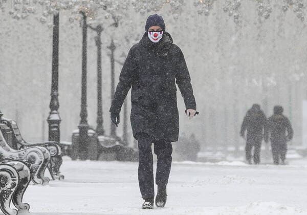 MOSCOW, RUSSIA - MARCH 31, 2020: A man wears a protective face mask in Nikolskaya Street during a snowfall. Russian President Vladimir Putin declared a week off work from 28 March to 5 April 2020 and urged people to stay home to prevent the spread of the COVID-19 coronavirus. From 30 March 2020, the Moscow government imposed home isolation for all Moscow residents, regardless of their age. Sergei Bobylev TASS  TS0D3FCC