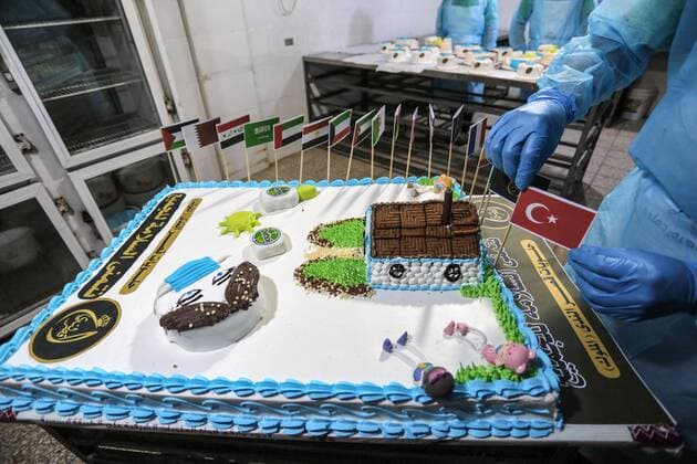 March 31, 2020, Khan Yunis, Gaza Strip, Palestinian Territory: Palestinians put final touches on cakes that portrays a woman wearing a facemask with model of bottel of Dettol to sterilize, at their shop in Khan Yunis in the southern Gaza Strip on March 31, 2020. The United Nations has warned that a COVID-19 outbreak in Gaza could be disastrous, given the high poverty rates and weak health system in the coastal strip under Israeli blockade since 2007. Authorities in Gaza have said that more than 2,700 Palestinians are in home-isolation, mostly people who had returned from Egypt Khan Yunis Palestinian Territory - ZUMAap3_ 20200331_zaf_ap3_131 Copyright: xAshrafxAmrax