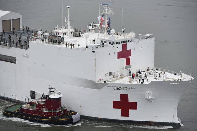 Tugboats assist USNS Comfort up the Hudson River as the hospital ship enters New York City, on March 30, 2020. Federal, state, and local agencies provide a security escort for the patrol.  WAX2020033123 PO2xZACHARYxHUPP