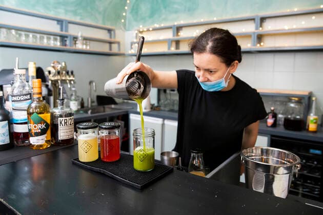 Izabela Rosiak prepares cocktails with a face mask in the bar in the Jar in B