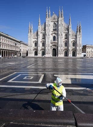 (200331) -- MILAN (ITALY), March 31, 2020 (Xinhua) -- A sanitation worker wearing a protective suit and a face mask cleans the ground at Piazza del Duomo in Milan, Italy, on March 31, 2020. The COVID-19 pandemic continued to advance in locked down Italy on Tuesday, bringing the total number of infections, fatalities and recoveries to 105,792, according to the latest data released by the country s Civil Protection Department. (Photo by Daniele Mascolo Xinhua) ITALY-MILAN-COVID-19-CASES 