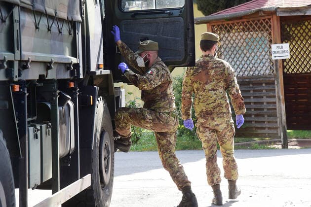 (200331) -- BOLOGNA (ITALY), March 31, 2020 (Xinhua) -- Soldiers are seen near a military truck carrying bodies of patients who died from COVID-19 infections from Lombardy, in Bologna, Italy, on March 31, 2020. The COVID-19 pandemic continued to advance in locked down Italy on Tuesday, bringing the total number of infections, fatalities and recoveries to 105,792, according to the latest data released by the country s Civil Protection Department. (Photo by Gianni Schicchi Xinhua) ITALY-BOLOGNA-COVID-19-CASES 