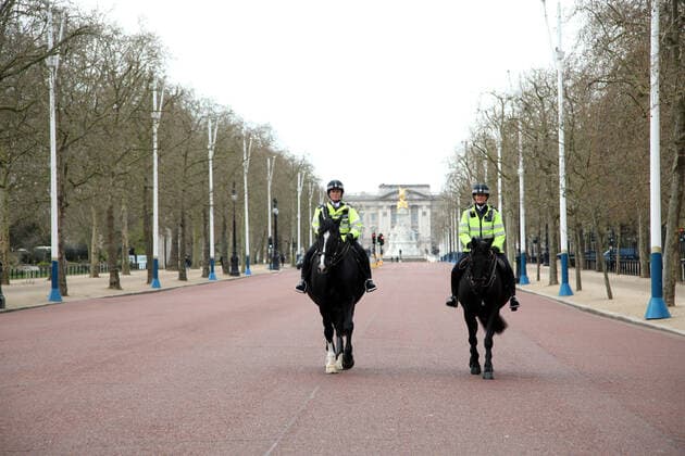 Day Nine of Lockdown in London. Mounted police offices patrol an almost deserted The Mall, with Buckingham Palace in the background. The country is on lockdown due to the COVID-19 Coronavirus pandemic. People are not allowed to leave home except for minimal food shopping, medical treatment, exercise - once a day, and essential work. COVID-19 Coronavirus lockdown, London, UK, on April 1, 2020 