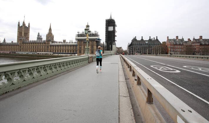 Day Nine of Lockdown in London. A runner crosses Westminster Bridge which has almost no traffic as the country is on lockdown due to the COVID-19 Coronavirus pandemic. People are not allowed to leave home except for minimal food shopping, medical treatment, exercise - once a day, and essential work. COVID-19 Coronavirus lockdown, London, UK, on April 1, 2020 