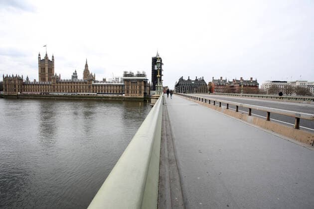 Day Nine of Lockdown in London. A handful of people cross Westminster Bridge at 12.50 whilst it is almost devoid of traffic as the country is on lockdown due to the COVID-19 Coronavirus pandemic. People are not allowed to leave home except for minimal food shopping, medical treatment, exercise - once a day, and essential work. COVID-19 Coronavirus lockdown, London, UK, on April 1, 2020 