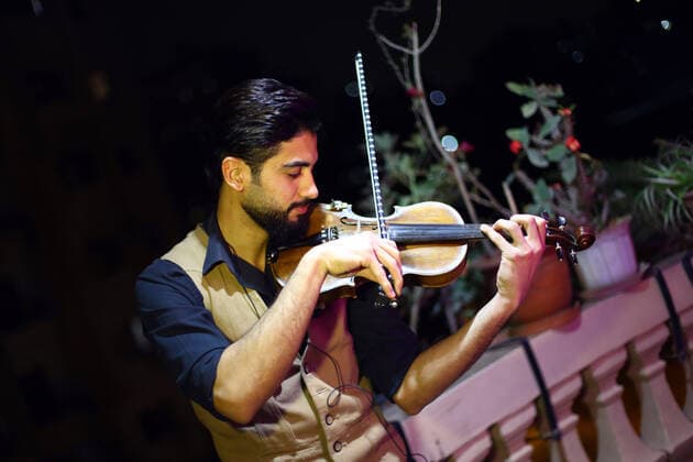 (200402) -- CAIRO, April 2, 2020 -- Egyptian violinist Mohammed Adel plays the violin during his balcony concert in Cairo, Egypt on March 31, 2020. Every night, Egyptian violinist Mohammed Adel gives a live concert from his balcony to entertain his neighbors during a coronavirus-caused nationwide nighttime curfew. TO GO WITH: Feature: Egyptian violinist s balcony performances amuse neighbors during nighttime curfew ) EGYPT-CAIRO-CURFEW-BALCONY CONCERT AhmedxGomaa 