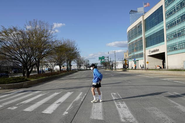 A man wears a protective face mask crossing a quiet the West Side Highway during rush hour near where the USNS Comfort Navy ship is docked at Pier 90 on the Hudson River in New York City on Wednesday, April 1, 2020. The floating hospital in the form of a Navy ship will arrive in New York City on Monday to relieve pressure on hospitals already overwhelmed with coronavirus patients. The USNS Comfort is set to dock around 10 a.m. and it will be ready to take in patients within 24 hours.  NYP20200401206 JOHNxANGELILLO