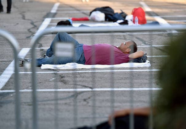 April 1, 2020 - Las Vegas, Nevada, U.S. - A man lays in an area marked by painted boxes at a temporary homeless shelter set up in a parking lot at Cashman Center amid the coronavirus pandemic on April 1, 2020, in Las Vegas, Nevada. Local officials opened the makeshift shelter after another local shelter closed when a homeless man staying there tested positive for the coronavirus. Las Vegas USA - ZUMAbk3_ 20200401_zaf_bk3_010 Copyright: xDavidxBeckerx