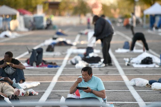 News Bilder des Tages April 1, 2020 - Las Vegas, Nevada, U.S. - People prepare a place to sleep in an area marked by painted boxes at a temporary homeless shelter set up in a parking lot at Cashman Center amid the coronavirus pandemic on April 1, 2020, in Las Vegas, Nevada. Local officials opened the makeshift shelter after another local shelter closed when a homeless man staying there tested positive for the coronavirus. Las Vegas USA - ZUMAbk3_ 20200401_zaf_bk3_013 Copyright: xDavidxBeckerx