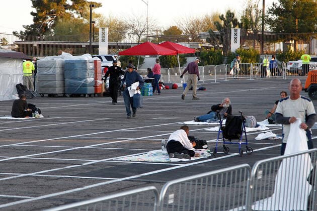 A homeless individual (center) arrives at a temporary open air shelter at the Cashman Center parking lot during the Coronavirus closure of Hotels and Casino s in Las Vegas, Nevada on Wednesday, April 1, 2020.  LAV2020040107 JAMESxATOA