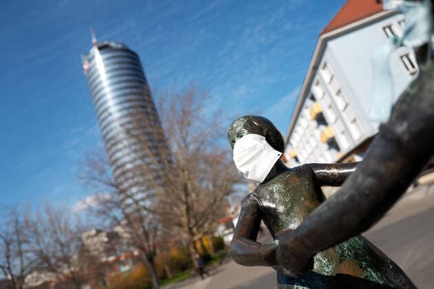 The statue of the two dancing girls in the center of Jena, who were wearing breathing masks by unknown persons In the background of the JenTower Photo from 2 4 2020 downtown Jena