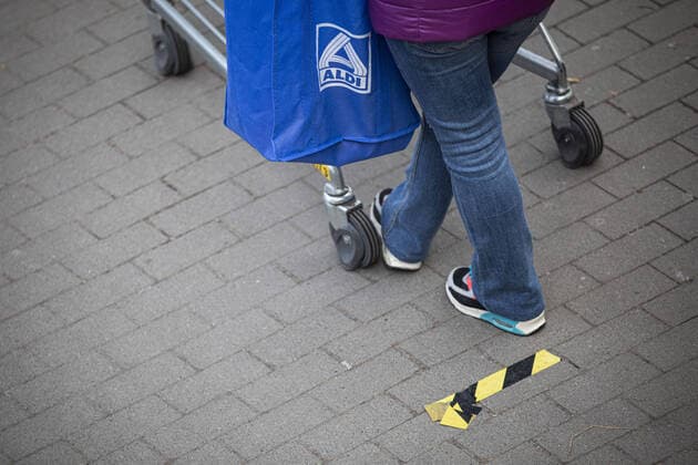 A woman with an Aldi bag is standing with her shopping trolley at a marker in front of a supermarket waiting for admission, taken in Goerlitz, 02 04 2020 Due to the spread of corona virus there are admission restrictions in supermarkets Goerlitz Germany Copyright: xFlorianxGaertner photothek.netx