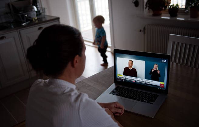200402 A woman follows a television broadcast via SVT play where Anders Tegnell, the state epidemiologist Public Health Agency, holds a press conference on the occasion of the Coronavirus, Covid 19, April 2, 2020 in Stockholm,  Copyright: NILSxJAKOBSSON 47113310st
