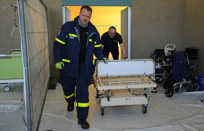 20 helpers from THW, DRK, DRLG and the fire brigade will help to set up the beds in the gymnasium in Marpingen on Thursday 02 04 2020 The gymnasium is to serve as a care centre for corona patients A total of 42 beds will be collected by helpers from hospitals and nursing homes and brought to the gymnasium and set up bub
