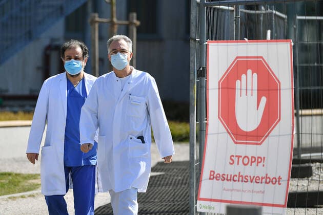 Dr Reza GHOTBI, head of vascular surgery and Dr Wolfgang Gesierich, head of the clinic for pneumology at the Lung Centre Munich West, come from the clinic with protective masks and mouthguards,Passing a sign STOP VISITS PROHIBITED on 02 04 2020 Too many corona i