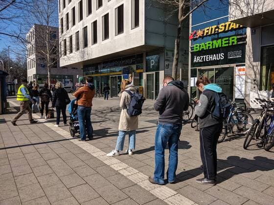 April 2, 2020, Munich, Bavaria, Germany: Due to social distancing regulations in Germany, customers at a Deutsche Post and Postbank branch in Munich, Germany back up onto the sidewalk. Munich Germany - ZUMAb160 20200402_zbp_b160_002 Copyright: xSachellexBabbarx