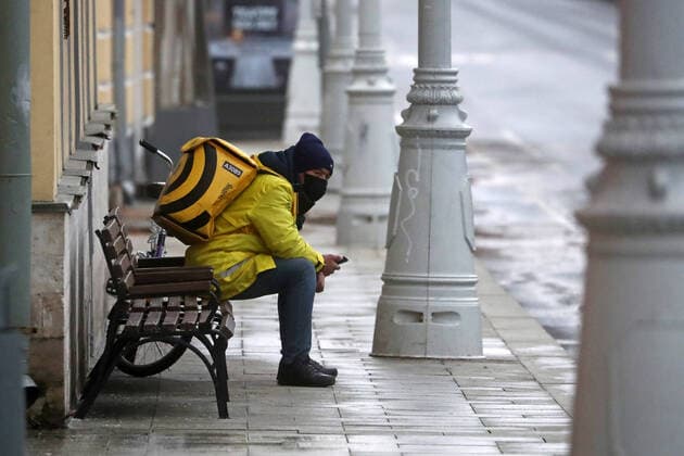 MOSCOW, RUSSIA - APRIL 2, 2020: A Yander Food courier on a bench. The Moscow authorities imposed home isolation for all Moscow residents, regardless of their age, and restrictions on movement within the city, effective since March 30, 2020, as a measure to contain the spread of the COVID-19 coronavirus infection. Violations of the stay-at-home order carry fines ranging from 15,000 to 40,000 rubles for non-infected people, and up to 1m rubles or imprisonment for up to 3 years for infected people, depending on the severity of consequences. Stanislav Krasilnikov TASS TS0D43D2