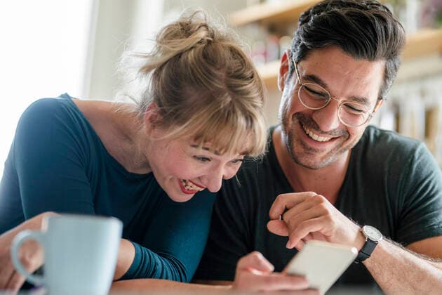 Happy couple looking at smartphone together model released Symbolfoto property released  KNSF07664