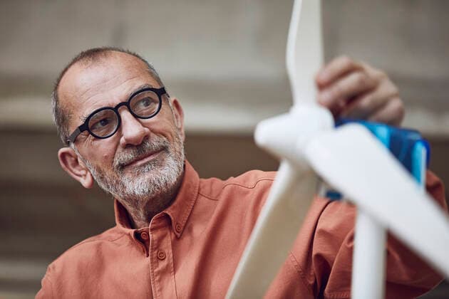 IMAGO Creative: Corporate: Klimaschutz, Digitalisierung und Urbanisierung Senior engineer working on wind energy solutions, looking at wind turbine model released Symbolfoto property released  MCF00571