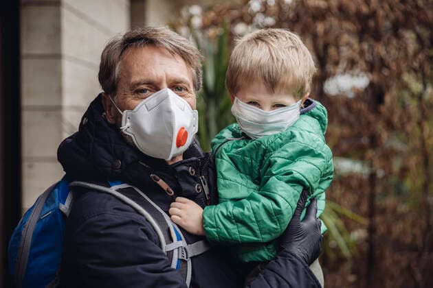 Father carrying son, both wearing protective maska, outdoors model released Symbolfoto property released  MFF05085