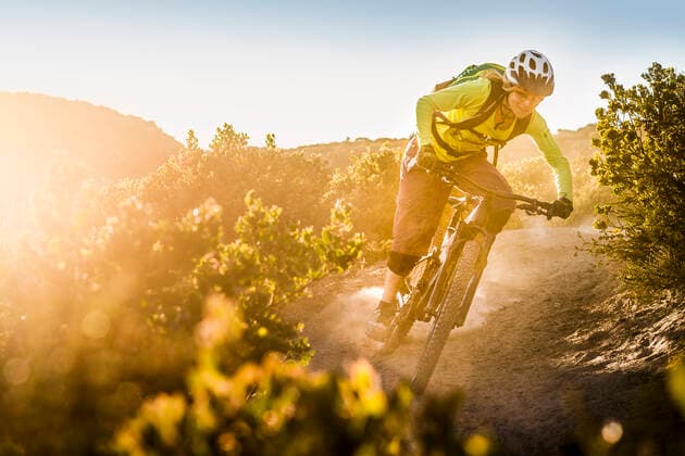 Female moutainbiker riding on dirt path during sunset, Fort Ord National Monument Park, Monterey, California, USA model released Symbolfoto  MSUF00237