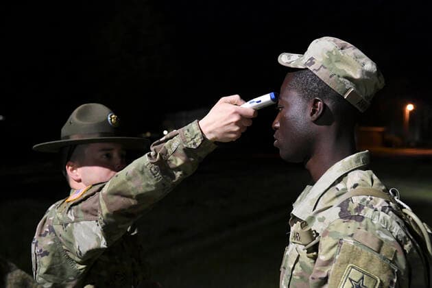 March 31, 2020 - Fort Jackson, South Carolina, United States - Staff Sgt. Joshua Cruz, a drill sergeant assigned to Company A, 2nd Battalion, 13th Infantry Regiment, takes the temperature of Pvt. Prince Aning, an Ohio National Guardsman, before he boards a bus March 31, 2020. Aning, along with roughly 400 other Basic Combat Training graduates, were held over at Fort Jackson, South Carolina, after graduation due to the COVID-19 virus. Each Soldiers temperature was recorded before boarding buses for Fort Lee, Virginia, where they will attend Advanced Individual Training. Fort Jackson United States - ZUMAz03_ 20200331_sha_z03_549 Copyright: xU.S.xArmyx