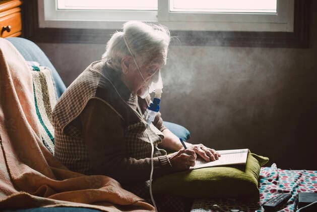 Senior woman using inhaler at home model released Symbolfoto  RAEF02360