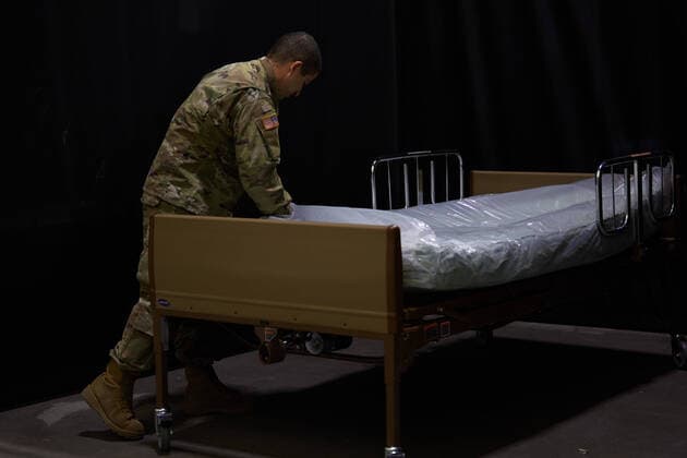 April 2, 2020, Worcester, Massachusetts, US: The Massachusetts National Guard in cooperation with FEMA and Umass Memorial Medical Cenetr are building a COVID-19, Corona Virus, field hospital to treat midlly ill paitents at the DCU Center in Worcester, Massachusetts. The facility will have 250 beds for those who are too sick to be home, but not in need of an Intensive Care Unit. A soldier assembles a hospital bed. Worcester US - ZUMAd211 20200402_zap_d211_022 Copyright: xAllisonxDinnerx