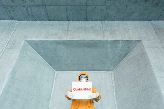 Portrait of man wearing protective clothing holding a quarantine sign model released Symbolfoto  WVF01463