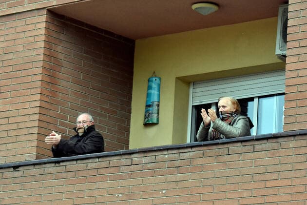April 2, 2020, El Vendrell, Spain: A couple applaud from the terrace of their house to show gratitude to the Covid-19 fighters..In Spain, every night at 08:00 pm and all the cities of the country, citizens who are confined at home during the state of alarm decreed by the Government of Spain since March 16, go out to their terraces and applaud to show gratitude to all the people such as health workers, police, fire fighters, supermarket staff, truckers, and cleaning staff for their great work in fighting the Covid-19 crisis. El Vendrell Spain - ZUMAs197 20200402_zaa_s197_080 Copyright: xRamonxCostax