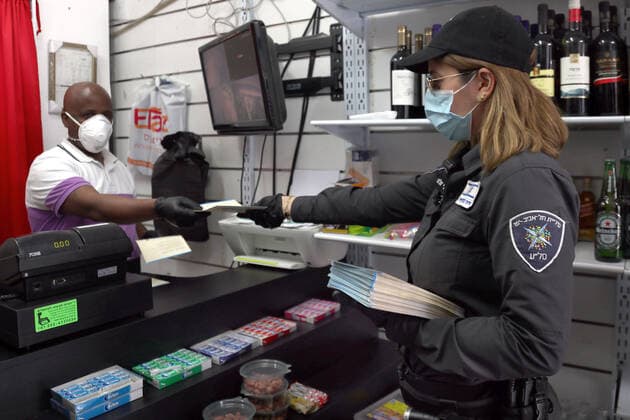 (200403) -- TEL AVIV, April 3, 2020 (Xinhua) -- An Israeli policewoman distributes information sheets of the Ministry of Health at a neighborhood in the central Israeli city of Tel Aviv on April 2, 2020. Israel reported 765 new confirmed cases of COVID-19 on Thursday, the daily highest so far, bringing the total number to 6,857, said the Ministry of Health. (Gideon Markowicz JINI Handout via Xinhua) MIDEAST-TEL AVIV-COVID-19 