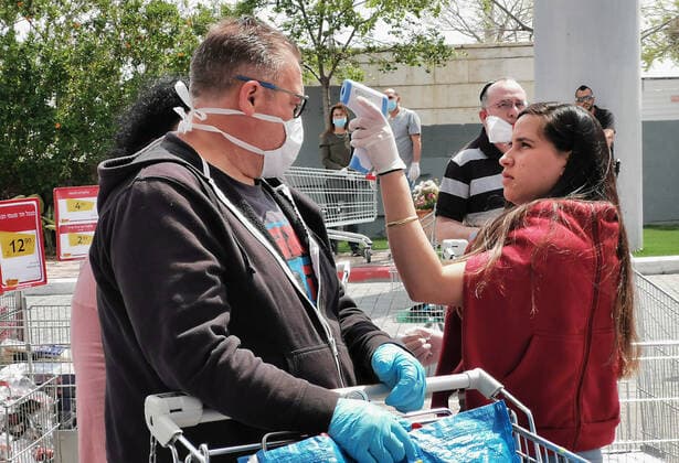 (200403) -- TEL AVIV, April 3, 2020 (Xinhua) -- An Israeli man wearing a face mask has his temperature checked at the entrance of a supermarket in the central Israeli city of Tel Aviv on April 2, 2020. Israel reported 765 new confirmed cases of COVID-19 on Thursday, the daily highest so far, bringing the total number to 6,857, said the Ministry of Health. (Gideon Markowicz JINI Handout via Xinhua) MIDEAST-TEL AVIV-COVID-19 