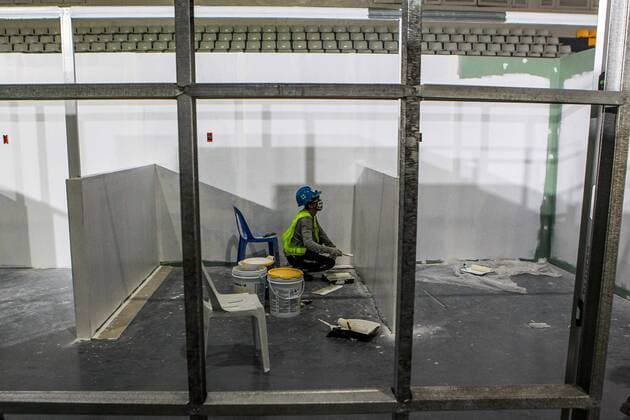 (200403) -- MANILA, April 3, 2020 -- A construction worker wearing a face mask works at the Rizal Memorial Coliseum which is being converted into a quarantine spot to contain the spread of novel coronavirus in Manila, the Philippines on April 3, 2020. ) PHILIPPINES-MANILA-COVID-19-QUARANTINE CENTER-CONVERSION ROUELLExUMALI 