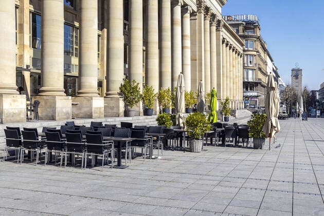 DEU, Germany, Baden Württemberg, Stuttgart, 03 04 2020 Königsbau at the pedestrian zone Stuttgart Königstraße Due to a general decree the shops remain closed, pedestrians are only occasionally on the move Empty street café at Schlossplatz
