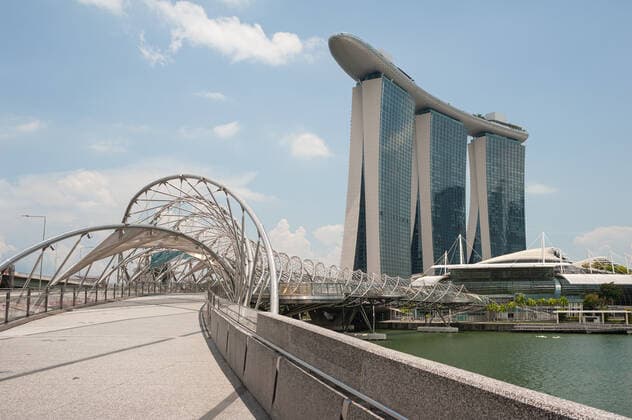02.04.2020, Singapur, Republik Singapur, Asien - Das Marina Bay Sands Hotel mit der Helix-Bruecke am Ufer des Singapore River. Seit dem Ausbruch der Corona-Pandemie ist die Zahl auslaendischer Besucher komplett zurueck gegangen. Fuer gewoehnlich wimmelt die Gegend um Marina Bay Sands von Touristen, ist jetzt aber bis auf wenige Personen total verwaist. *** 02 04 2020, Singapore, Republic of Singapore, Asia The Marina Bay Sands Hotel with the Helix Bridge on the banks of the Singapore River Since the outbreak of the Corona Pandemic, the number of foreign visitors has completely decreased.