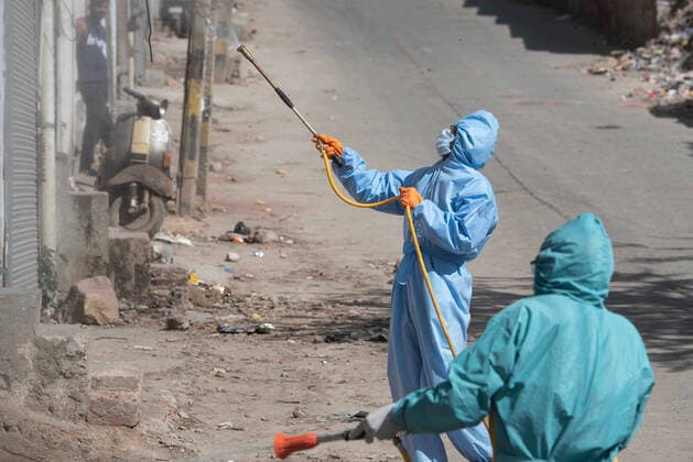 NEW DELHI, INDIA - APRIL 3: MCD workers wearing PPE suits spray disinfectant while sanitizing the streets, on day ten of the 21 day nationwide lockdown to curb the spread of coronavirus, at Anand Parbat in New Delhi, India, on Friday, April 3, 2020. (Photo by Sanchit Khanna Hindustan Times) Sanitation Drive During Three Week Lockdown To Stop Spread Of Coronavirus COVID-19
