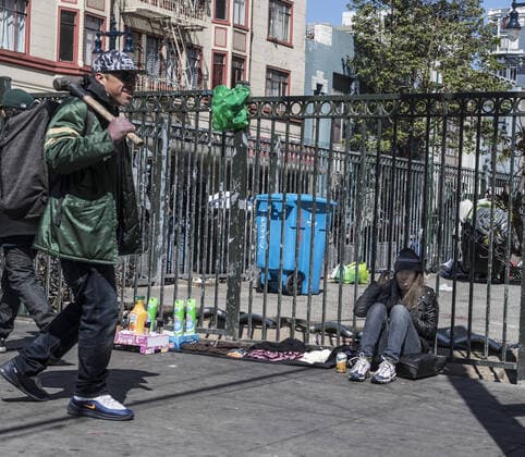 A woman sells orange juice and cleaning supplies on Turk Street in the Tenderloin district of San Francisco on Friday, April 3, 2020. San Francisco is trying to spread out their homeless to avoid the coronavirus.  SXP2020040306 TERRYxSCHMITT