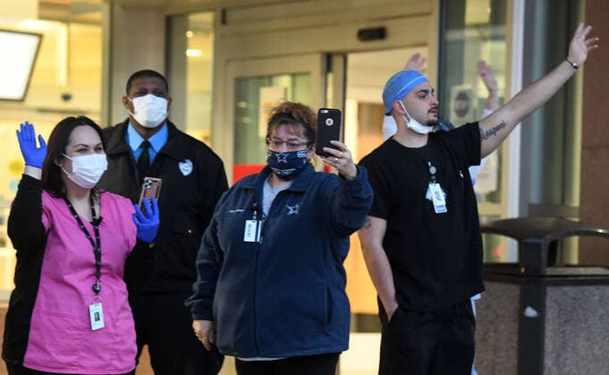 April 3, 2020, Racine, Wisconsin, USA: Emergency room staff members on duty watch and wave as hundreds of cars packed the campus of Ascension All Saints Hospital in Racine, Wisconsin Friday April 3, 2020 to show their support to the staff. The event, suggested by a NICU nurse, for cars to parade through the grounds flashing their headlights, was billed as Flashin First Friday because the traditional downtown First Fridays during which stores stay open late was canceled. So many cars came that the parade stalled that most cars just parked facing the hospital buildings and honked their horns for an hour. Racine County reported its first COVID-19 death Friday. Racine USA - ZUMAh154 20200403_znp_h154_020 Copyright: xMarkxHertzbergx