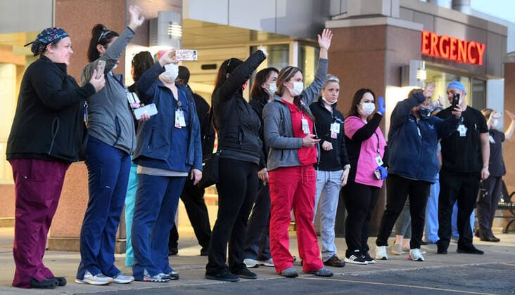 April 3, 2020, Racine, Wisconsin, USA: Emergency room staff members on duty watch and wave as hundreds of cars packed the campus of Ascension All Saints Hospital in Racine, Wisconsin Friday April 3, 2020 to show their support to the staff. The event, suggested by a NICU nurse, for cars to parade through the grounds flashing their headlights, was billed as Flashin First Friday because the traditional downtown First Fridays during which stores stay open late was canceled. So many cars came that the parade stalled that most cars just parked facing the hospital buildings and honked their horns for an hour. Racine County reported its first COVID-19 death Friday. Racine USA - ZUMAh154 20200403_znp_h154_021 Copyright: xMarkxHertzbergx