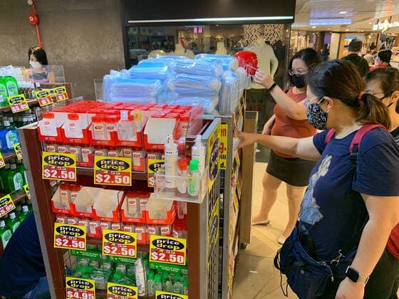 People buy face masks and sanitizers after the Singapore government announced tighter restrictions to fight the spread of COVID-19 at value dollar store in Singapore on April 4, 2020.  (125033597)