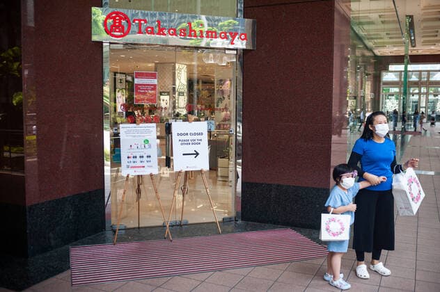 02 04 2020, Singapore, Republic of Singapore, Asia A mother is standing with her child in front of the Takashimaya Shopping Centre on Orchard Road Both wear mouthguards to prevent infection with the pandemic corona virus