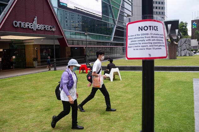 02 04 2020, Singapore, Republic of Singapore, Asia People in the business district at Raffles Place walk past a signpost to Covid 19 and wear a mouthguard to prevent infection with the pandemic corona virus To further limit the spread of the corona virus, measures have been introduced to maintain sa